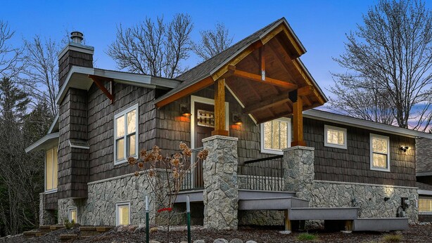 A modern house with stone walls, a wooden deck, and a stone foundation. - Riverside Retreat -breathtaking View Kayak ATV (Mountain)
