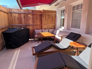 Enjoy al fresco dining and relaxation on the outdoor patio with a grill, table, and comfortable lounge chairs.