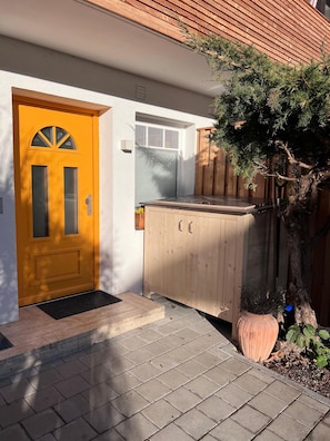 Enter a charming home through the inviting yellow door, featuring a semi-circular window above.