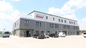 A modern building with a sign reading "SKRDESIGN" and several parked cars in front. - Apartment with shower (Garbsen)