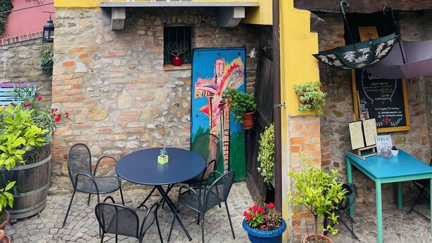 A yellow building with a balcony, outdoor seating area, and a mural. - Vacation home (Monforte d'Alba)