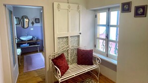 A bedroom with a bed, a window, a door, and a bathroom visible through an open door. - Vacation home (Monforte d'Alba)