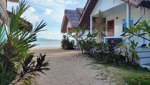 A beachfront property with thatched-roof structures, a sandy path leading to the beach, and tropical vegetation. - Sand Terrace Beach Bungalows (Ko Pha-ngan)