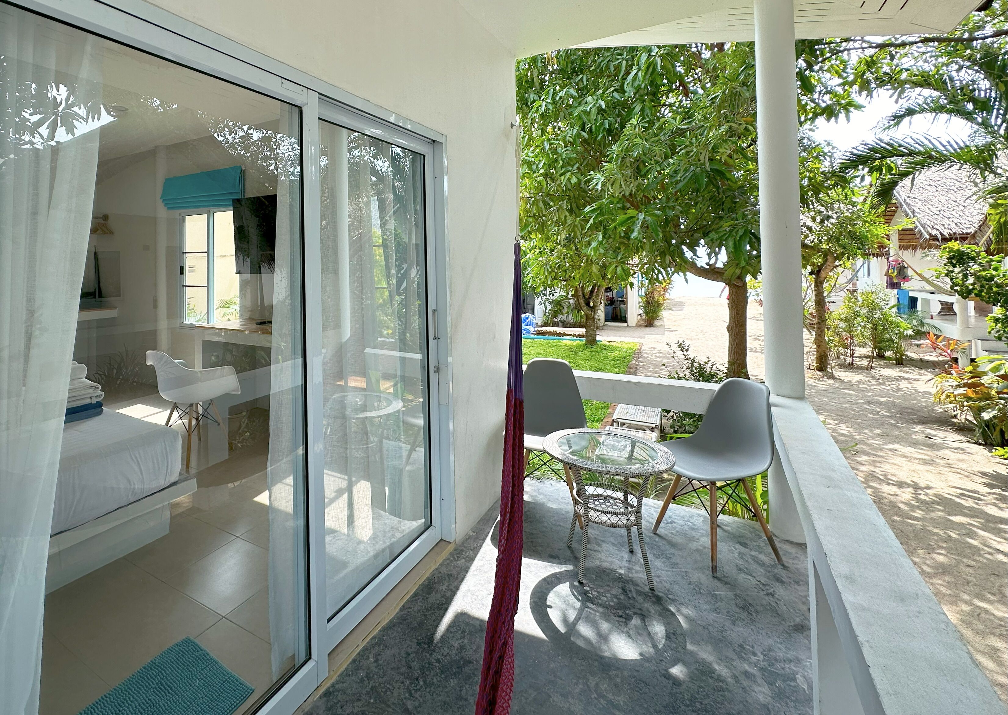 A room with a sliding glass door leading to an outdoor area with a table and chairs.