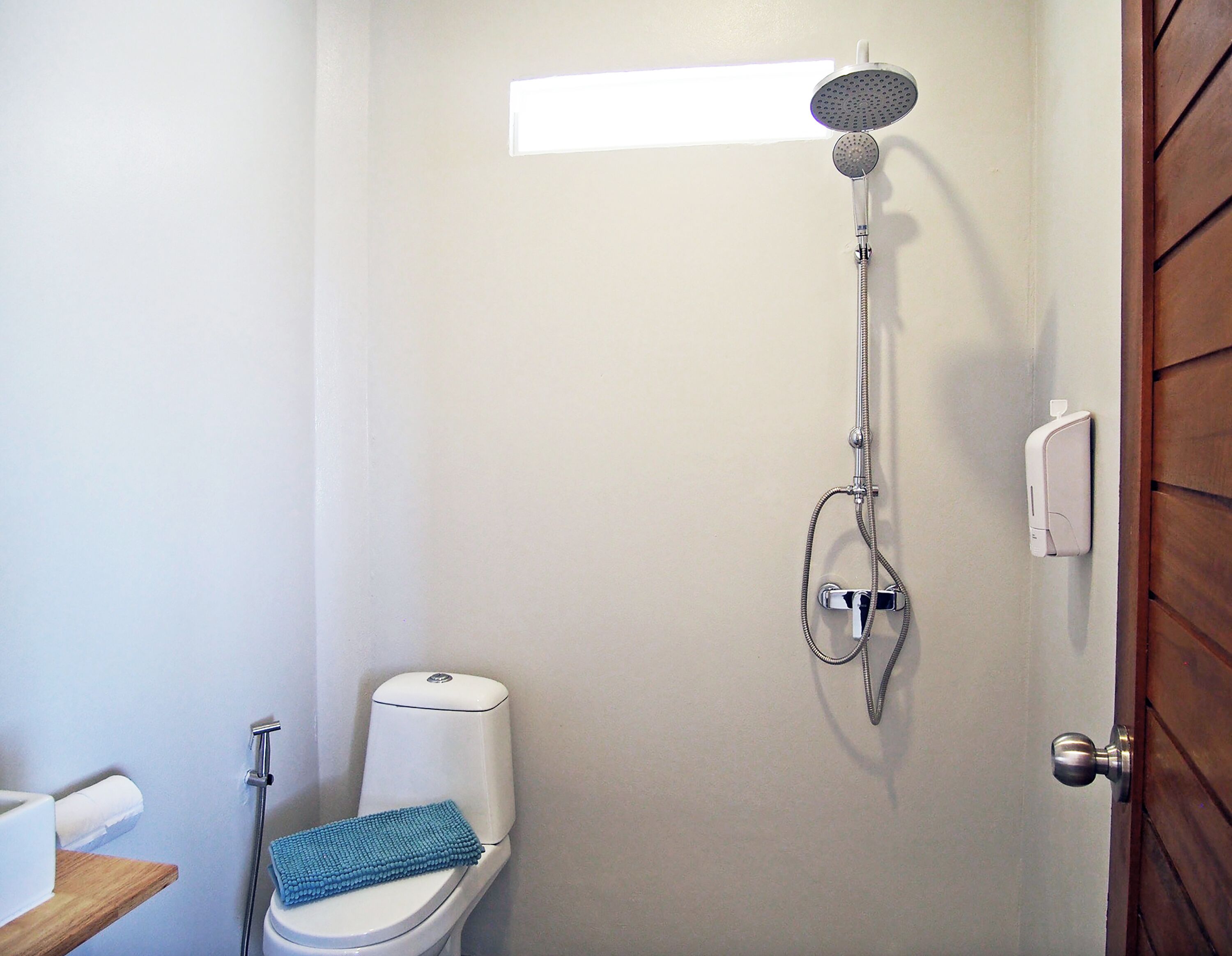 Un baño con inodoro, ducha y perchero.