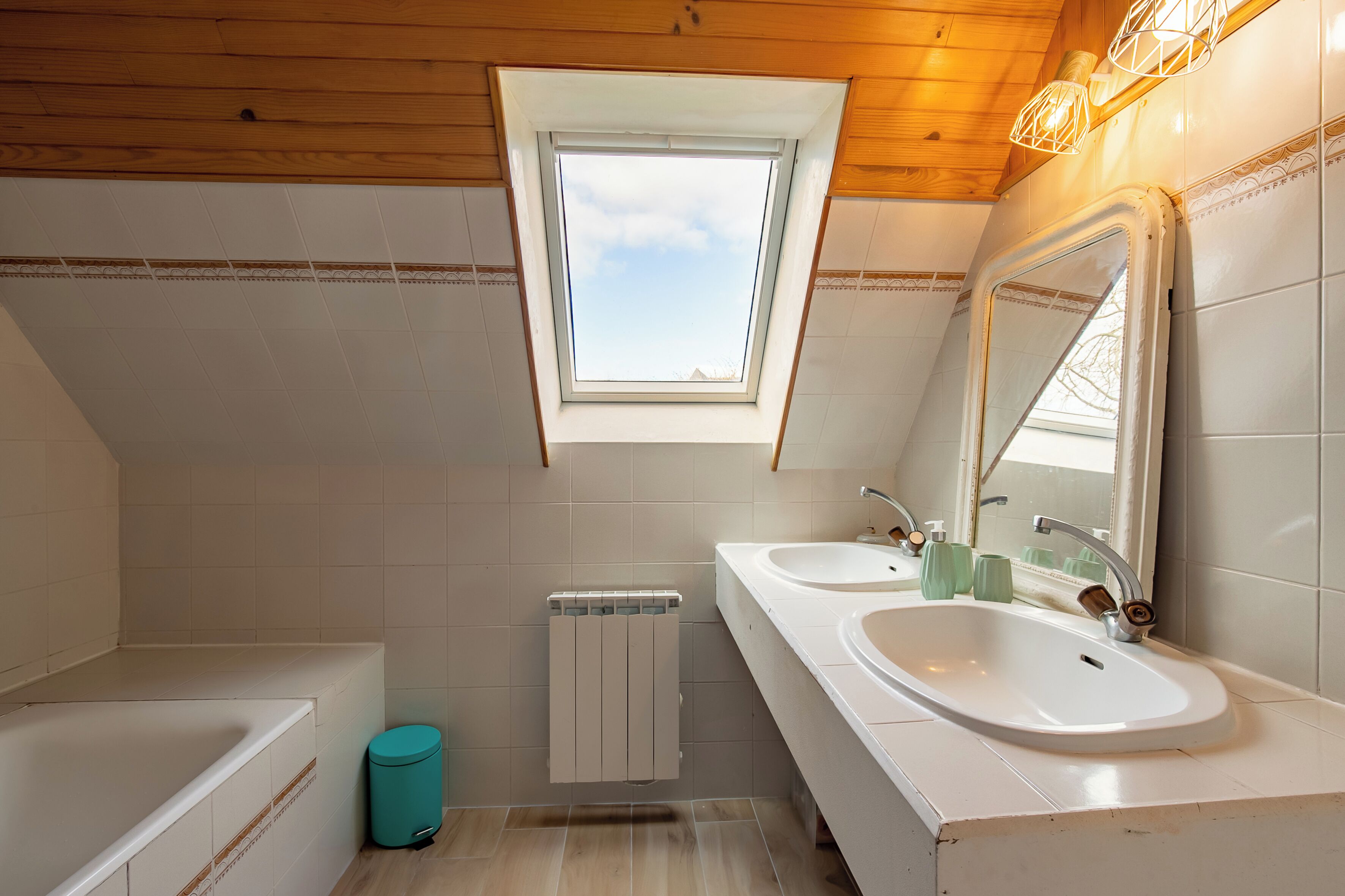 Une salle de bain moderne avec deux lavabos, une fenêtre et un miroir.