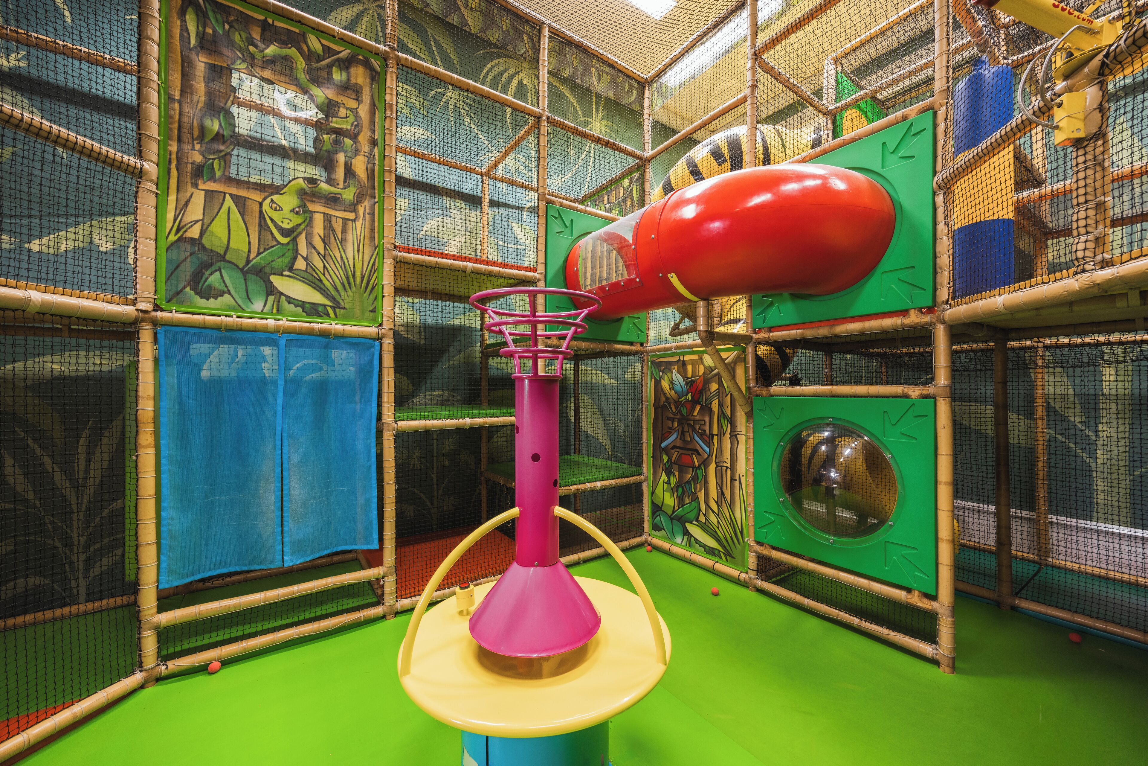 A play area with a climbing structure, a basketball hoop, and a ball pit.