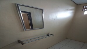 Un baño con espejo, toallero y suelo de baldosas.