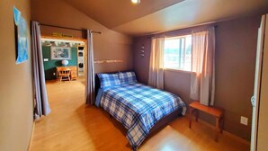 A bedroom with a bed, a wooden bench, a desk, and a chair. - Soaring Heights Loft, Home Away From Home (Forks)
