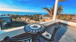 A balcony with a view of the sea, a tiled table, and chairs. - Du Parc Resort Mũi Né (Mui Ne)