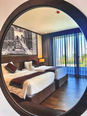 A hotel room with two beds, a cityscape mural, a large window with curtains, and a wooden floor. - Du Parc Resort Mũi Né (Mui Ne)