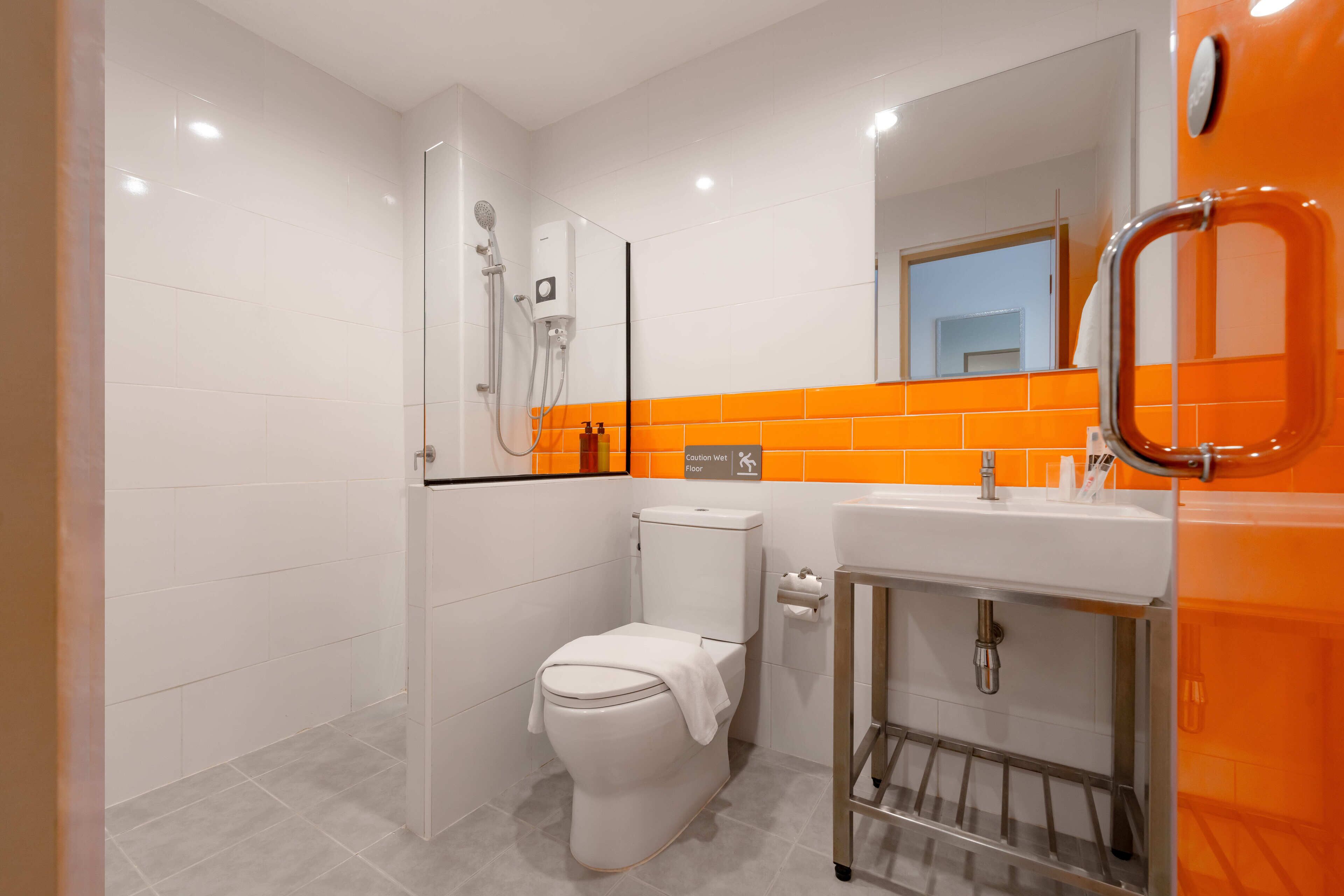 A modern bathroom with a shower, toilet, and sink.