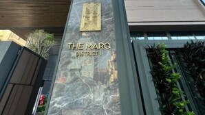 Un edificio alto con un cartel que dice 'THE MARQ DISTRICT 1'.