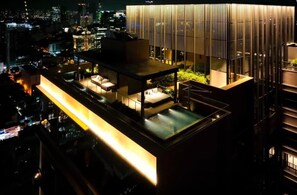 A modern rooftop terrace with a glass dining area, a pool, and a city view. - The Marq Apartment Quan 1  (Ho Chi Minh City)