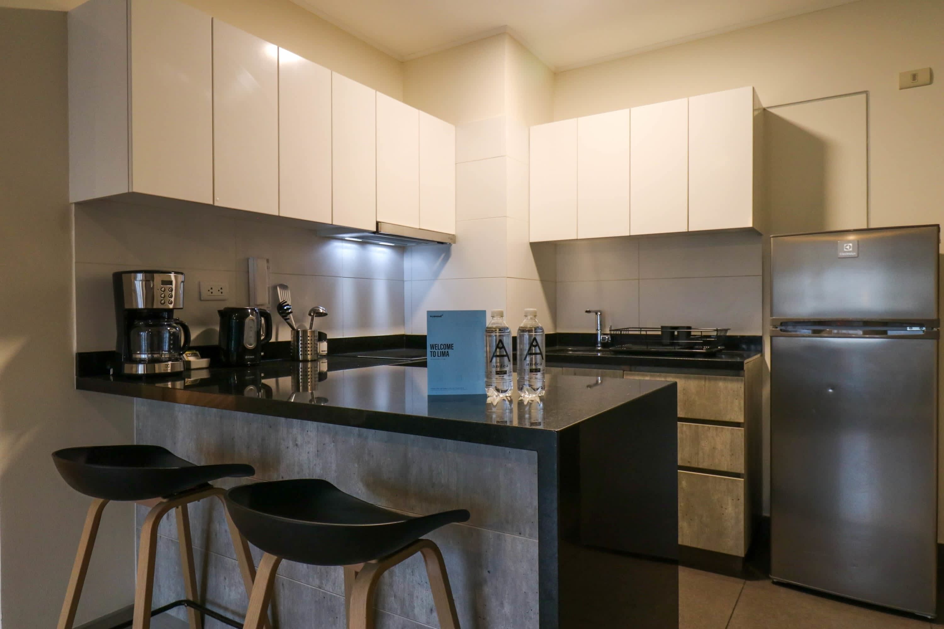 A modern kitchen with a central island, stainless steel appliances, and minimalist cabinetry.