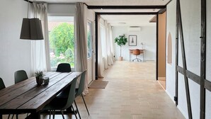 A modern interior with a wooden dining table, chairs, and a potted plant. - Beautiful House Skanör - Falsterbo (Skanör)