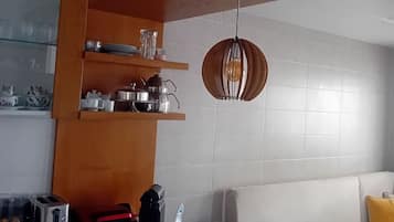 Eine moderne Küche mit Holzböden, einer Marmorarbeitsplatte und einer Pendelleuchte.