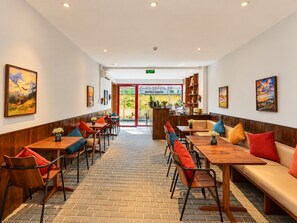 Un restaurant avec une salle à manger intérieure, un sol en briques et une vue sur l’extérieur.