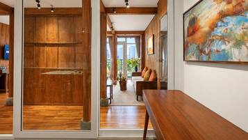 Interior moderno com piso de madeira, um banco e uma pintura na parede.