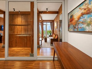 Un intérieur moderne avec un plancher en bois, un banc et un tableau accroché au mur.