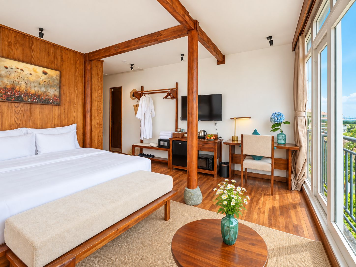 Une chambre d’hôtel avec un grand lit, un bureau avec un ordinateur, une télévision et une vue sur la ville.