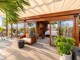 Una habitación moderna con cama, sofá y un ventanal grande.