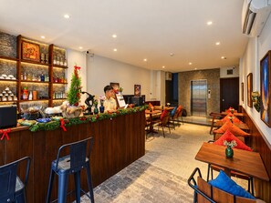 A hotel lobby with a reception desk, seating area, and an elevator. - Nexus House Lang Bao Chi (Ho Chi Minh City)