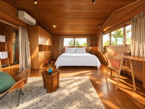 A spacious bedroom with a large bed, wooden walls, a desk, and a window with curtains. - Nexus House Lang Bao Chi (Ho Chi Minh City)