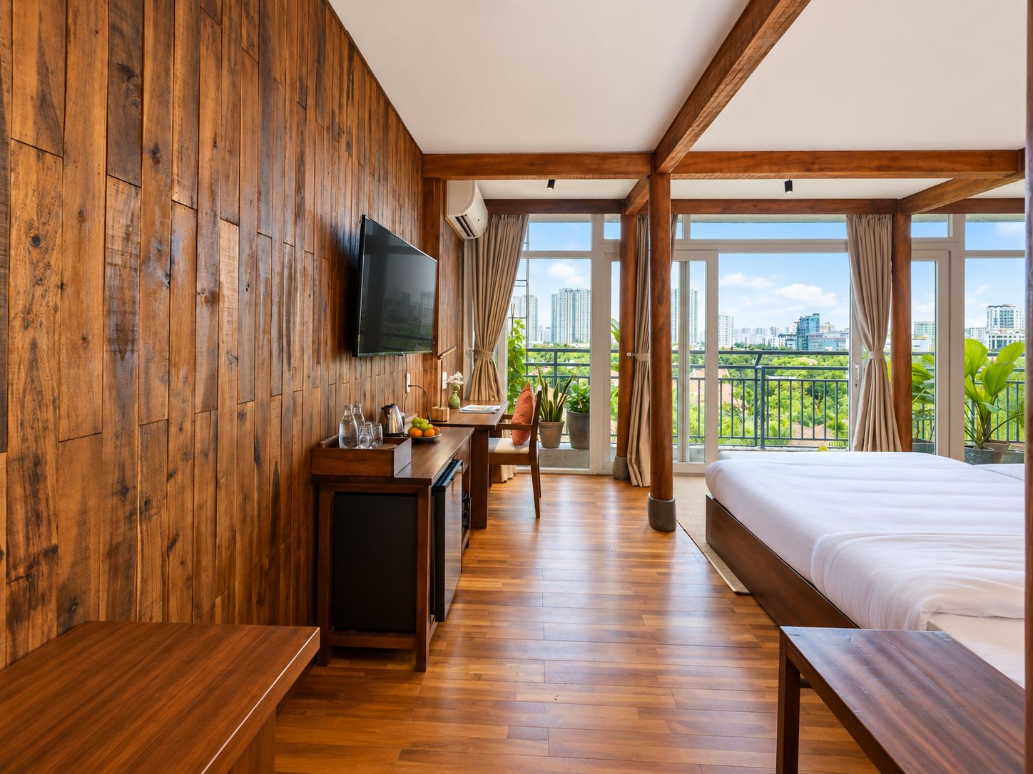 A hotel room with a wooden wall, a flat-screen TV, a balcony with a city view, and a bed.
