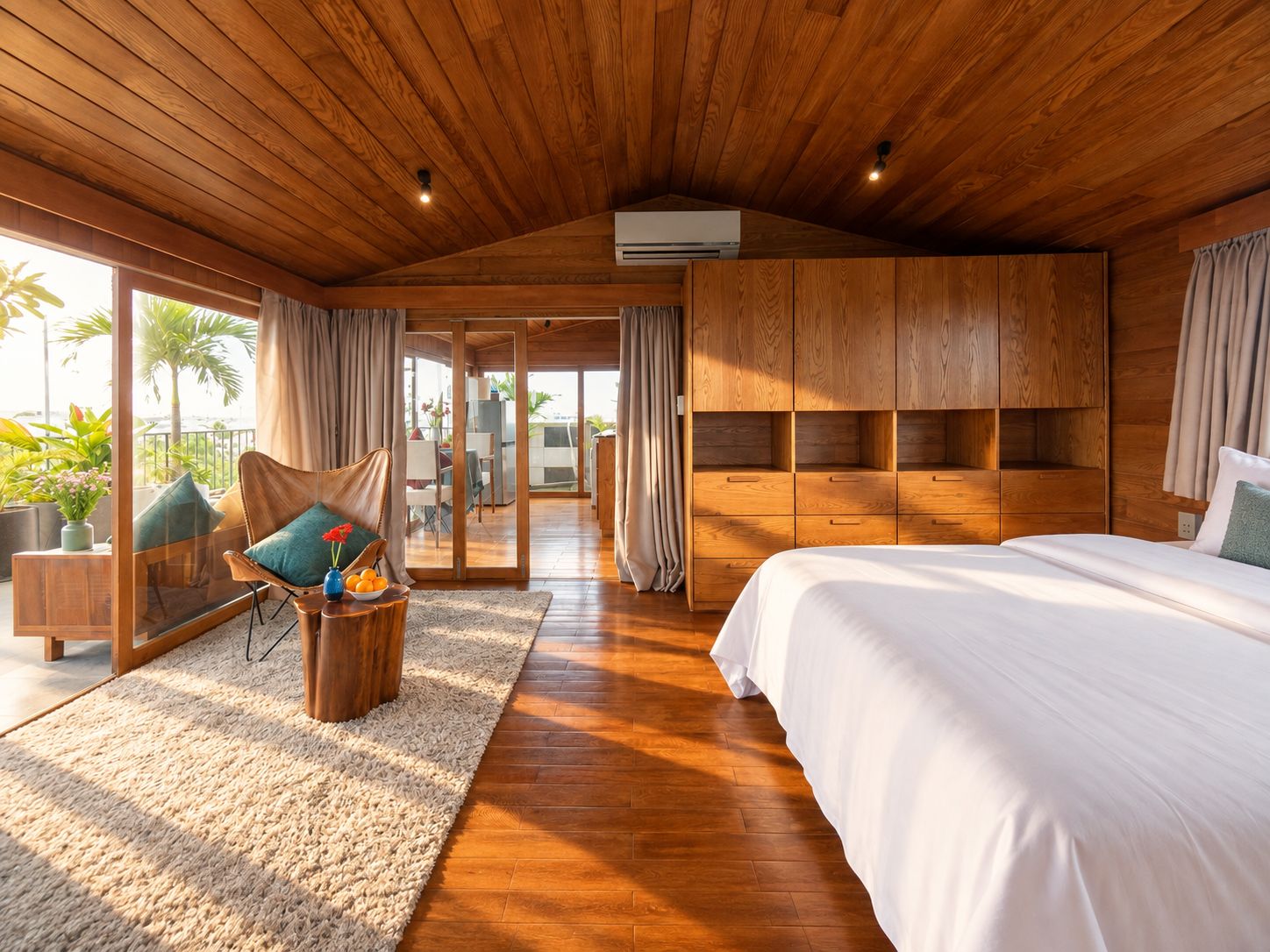 Un dormitorio amplio con una cama grande, techo de madera y puerta corrediza de vidrio que da a un balcón.