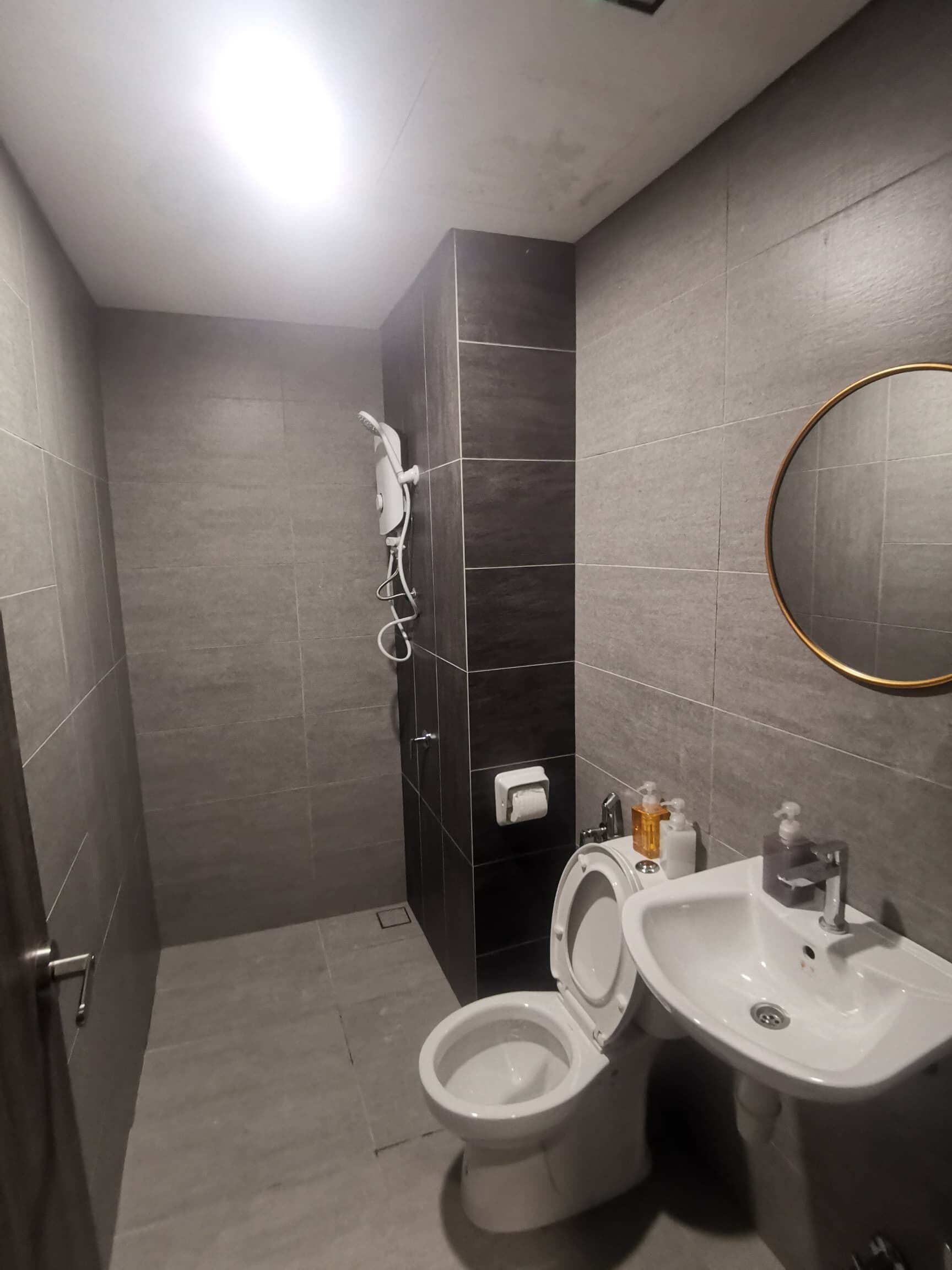 A modern bathroom with a toilet, sink, and shower.