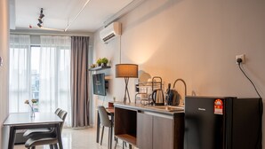 Cocina moderna con lavaplatos, estufa y refrigerador. Hay un comedor con mesa y sillas.