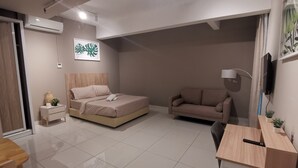 Un dormitorio moderno con una cama, un sofá, un escritorio y un televisor.