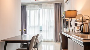 Una cocina moderna con comedor, hervidor y televisor.