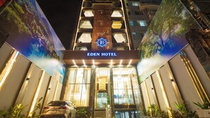 L’hôtel Eden se distingue par son entrée imposante, ses grandes fenêtres verticales et son logo central.