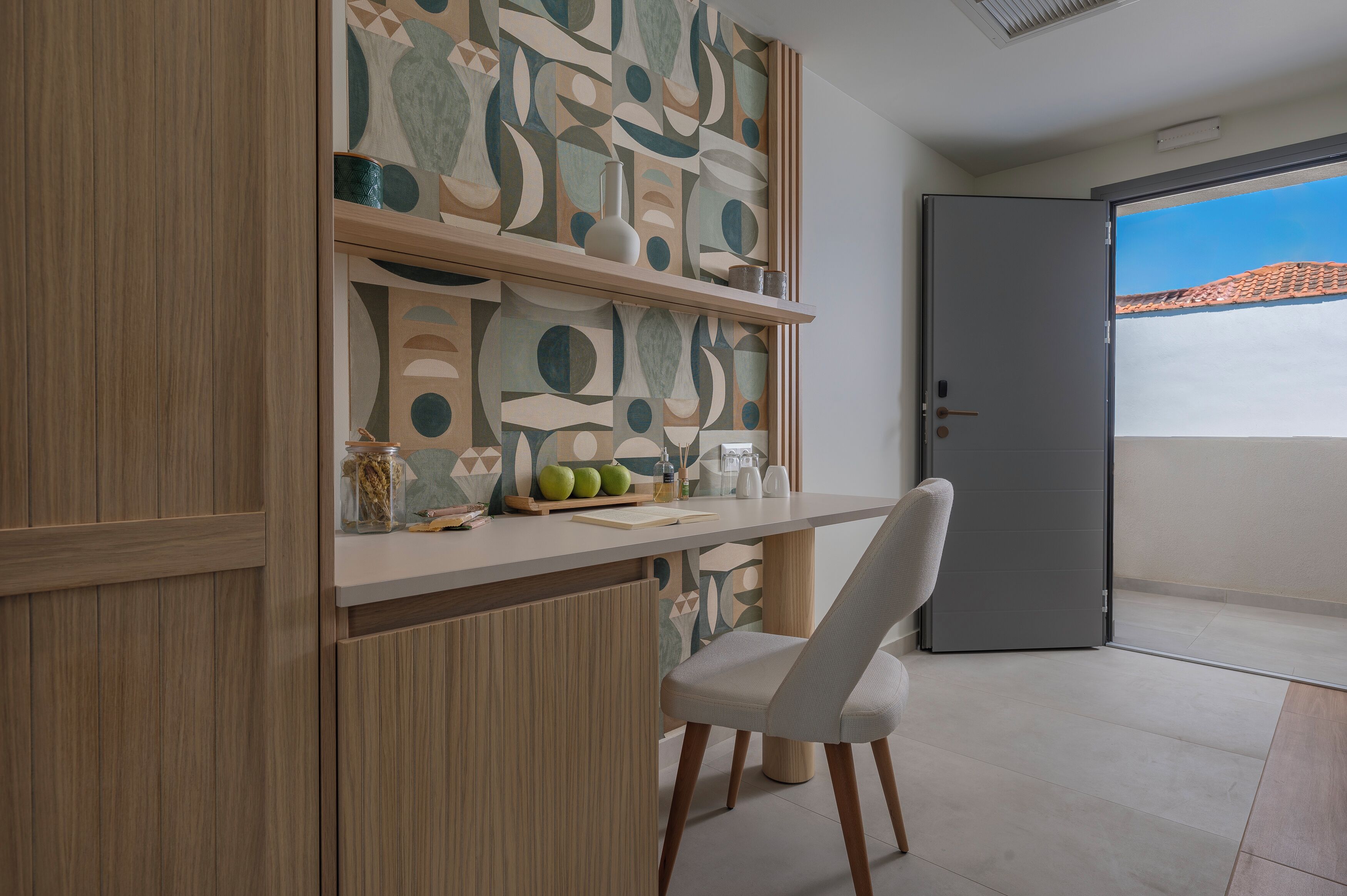 A modern kitchen with a wooden cabinet, a white chair, and a decorative wall.