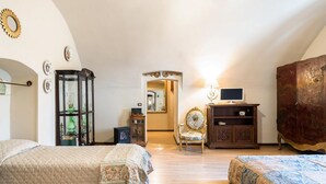 A bedroom with two beds, a wooden cabinet, a chair, and a television. - 3975 Il Feudo - Suite Decò by Barbarhouse (Bari)