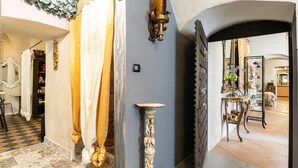 A hallway with patterned flooring, a decorative column, and a shoe rack. - 3975 Il Feudo - Suite Decò by Barbarhouse (Bari)
