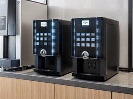Two Brewmatic coffee machines with illuminated buttons on a countertop.