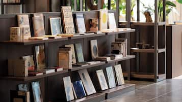 A bookshelf with various books and framed pictures, shelves with a dark wood finish, and a tiled floor.