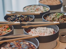 Une variété de plats servis dans des bols, accompagnés de baguettes, ce qui laisse supposer qu’il s’agit d’un repas.