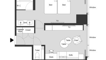 Distribución de una Suite Junior Club con dos camas, televisión, baño, escritorio, sofá y mesa.
