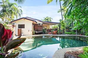 A modern house with a pool, surrounded by lush tropical vegetation. - Relax at Sudbury Shores Beach House- Tropical Kewarra Beach Retreat | Lagoon Pool + Outdoor Bath (Kewarra Beach)