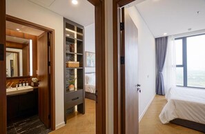 Un dormitorio moderno con una cama grande, un armario empotrado y un tocador con espejo.