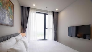 Une chambre d’hôtel moderne avec un grand lit, un téléviseur à écran plat et une vue par la fenêtre.