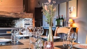 A dining table set with wine glasses, a vase with flowers, and plates. - Amazing home in Gedinne with sauna (Gedinne)