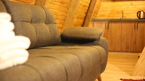 A cozy room with a sofa and wooden walls. - Pagen Bungalov (Hopa)