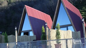 A building with a unique triangular roof design and wooden fence. - Pagen Bungalov (Hopa)