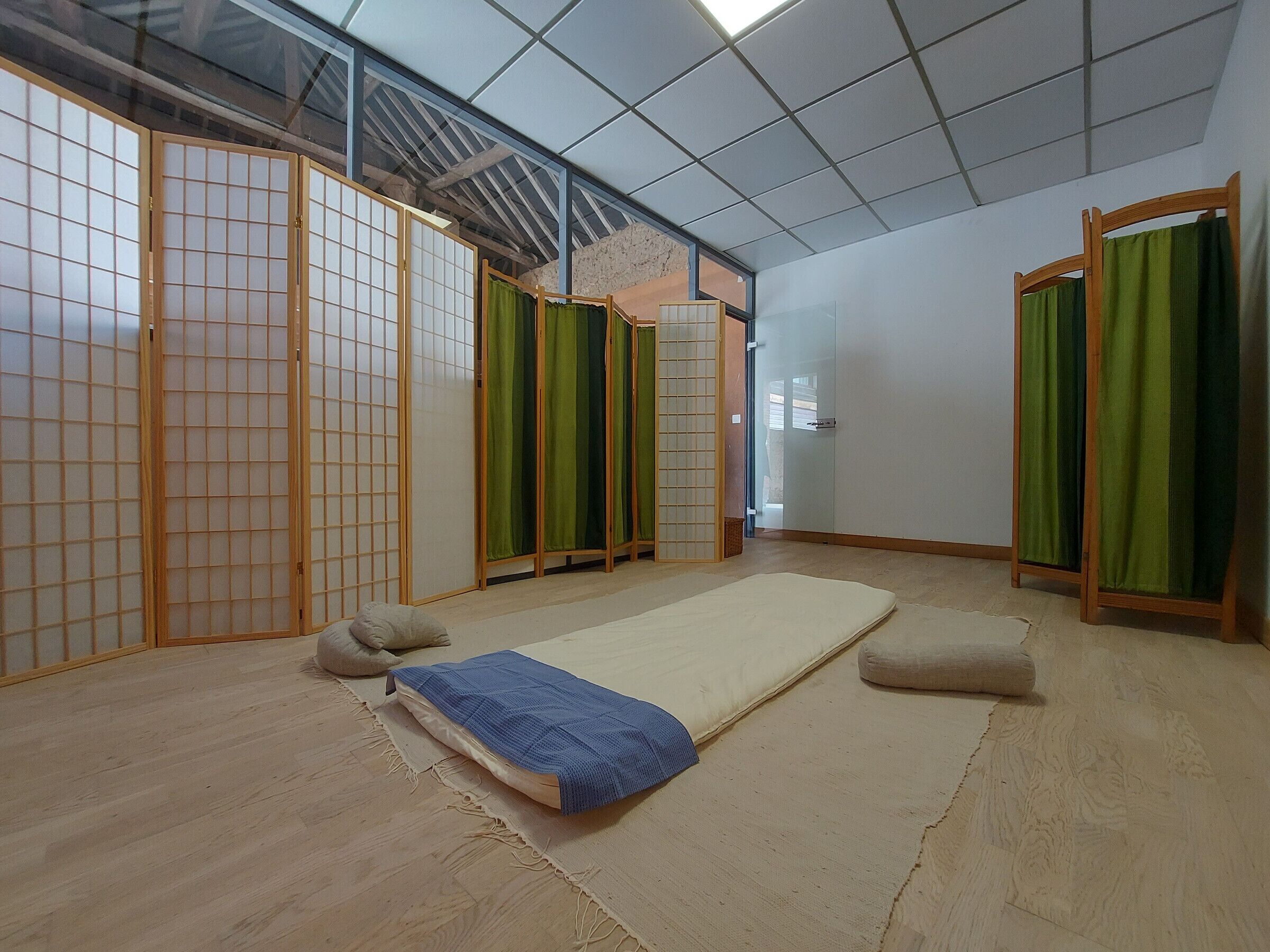 A traditional Japanese room with tatami flooring, shoji screens, and a futon bed.