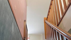 Una escalera de madera con barandilla que sube.